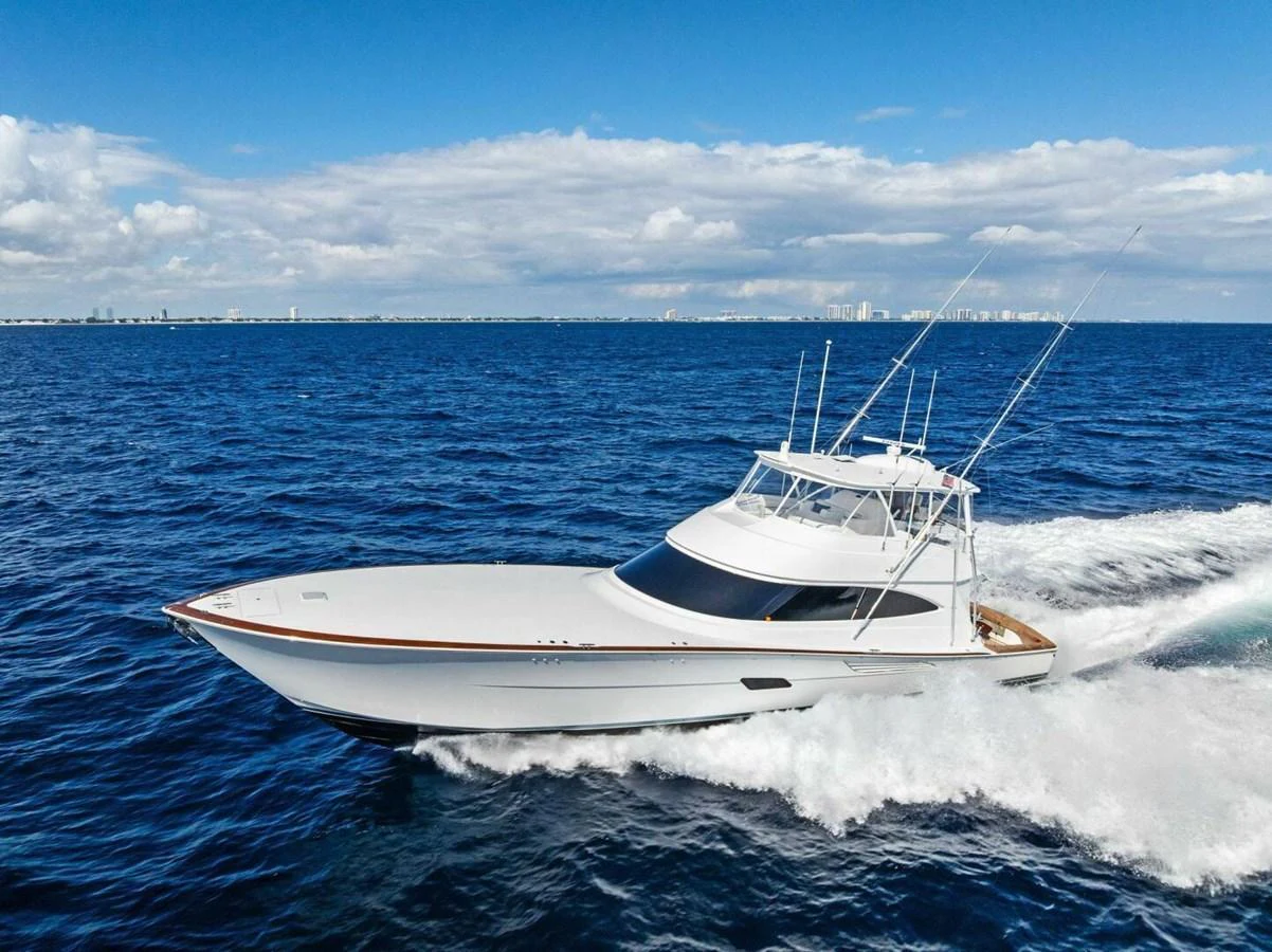 A sleek yacht cruises swiftly through the open sea under a clear blue sky. aboard TEAM HARVEY I Yacht for Sale