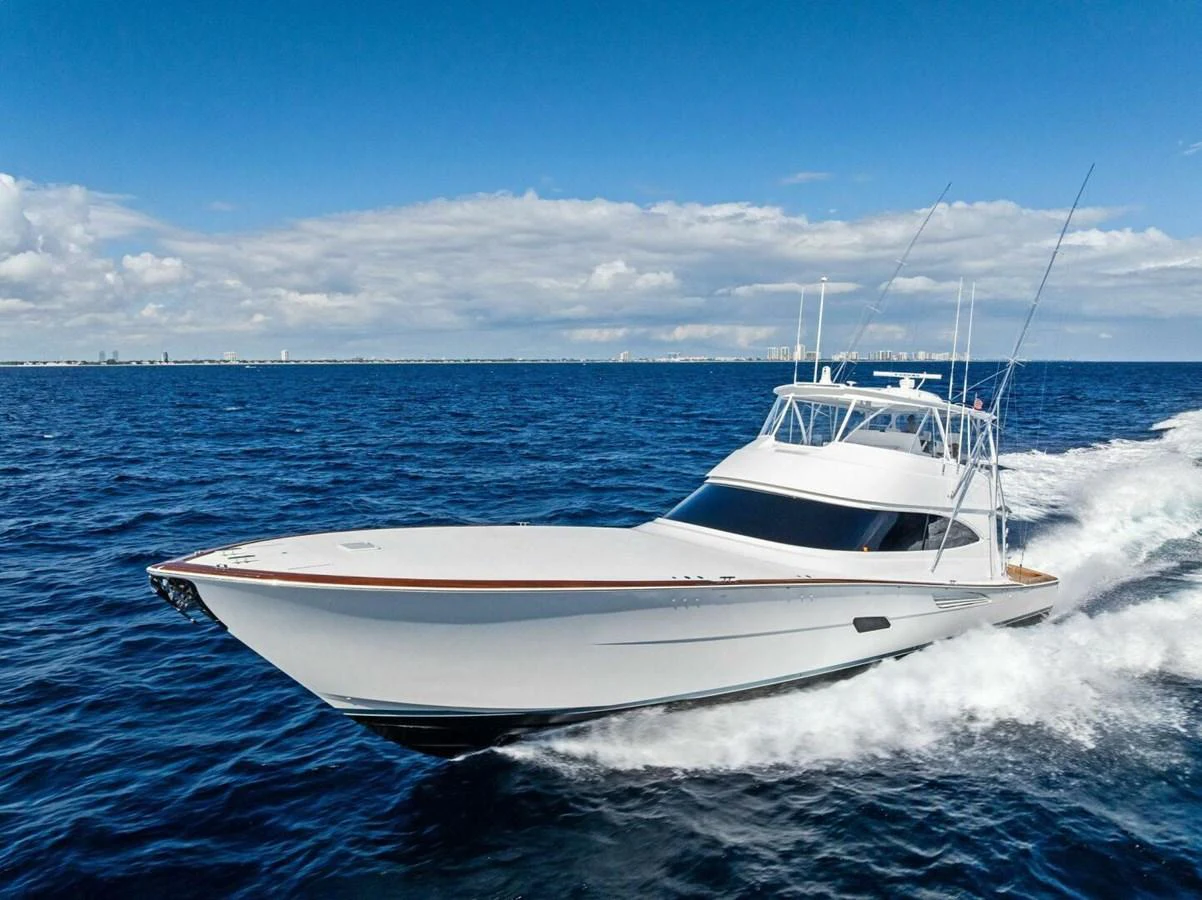 A sleek yacht cruises swiftly across the open sea under a clear blue sky. aboard TEAM HARVEY I Yacht for Sale