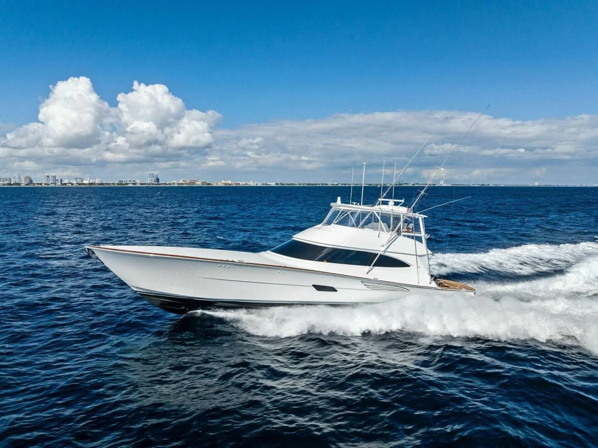 A sleek yacht cruises swiftly on the open water under a clear blue sky. aboard TEAM HARVEY I Yacht for Sale