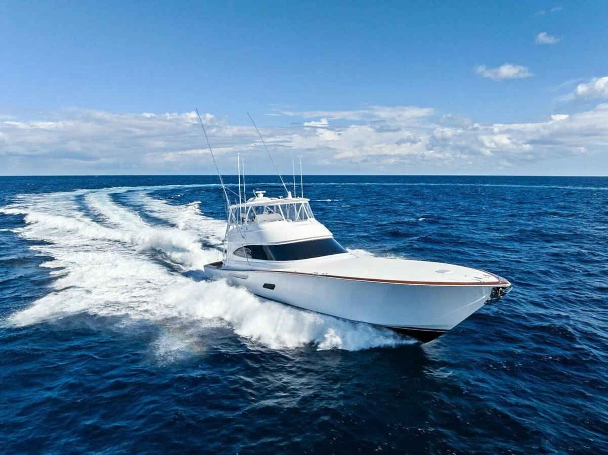A sleek yacht cruises swiftly through the open ocean under a clear blue sky. aboard TEAM HARVEY I Yacht for Sale