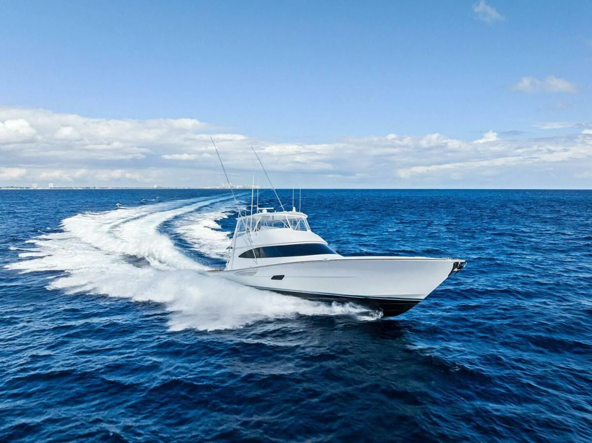 A sleek yacht cruises swiftly across the open ocean under a clear blue sky. aboard TEAM HARVEY I Yacht for Sale
