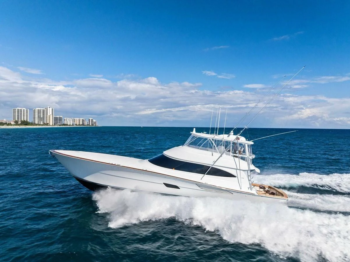 A sleek yacht cruises swiftly through the open water under a clear blue sky. aboard TEAM HARVEY I Yacht for Sale