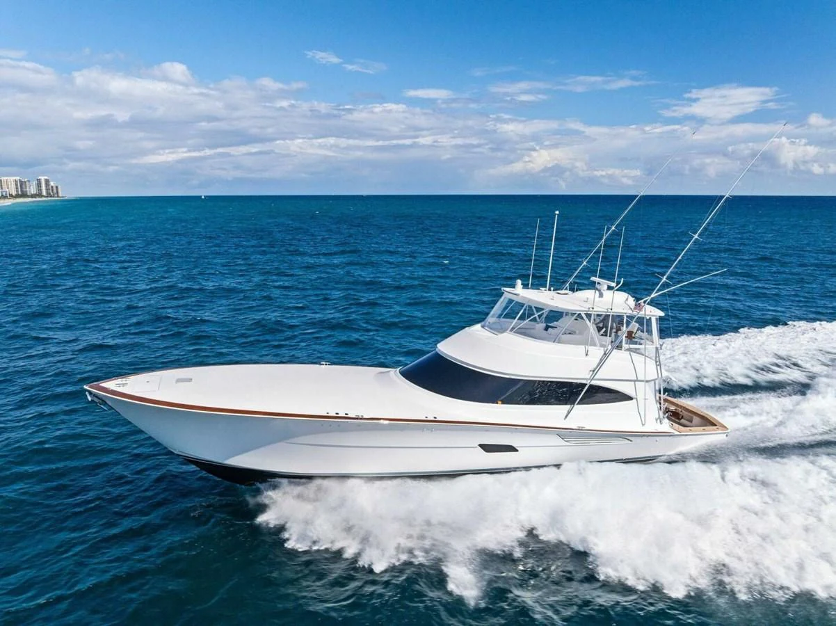 A sleek yacht cruises swiftly through the open sea under a clear blue sky. aboard TEAM HARVEY I Yacht for Sale
