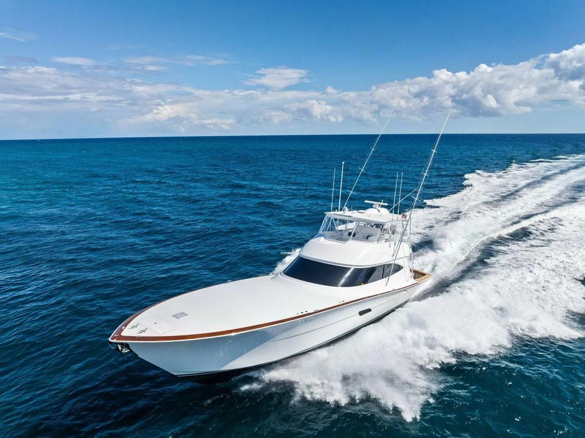 A sleek yacht cruises swiftly through the open sea under a clear blue sky. aboard TEAM HARVEY I Yacht for Sale