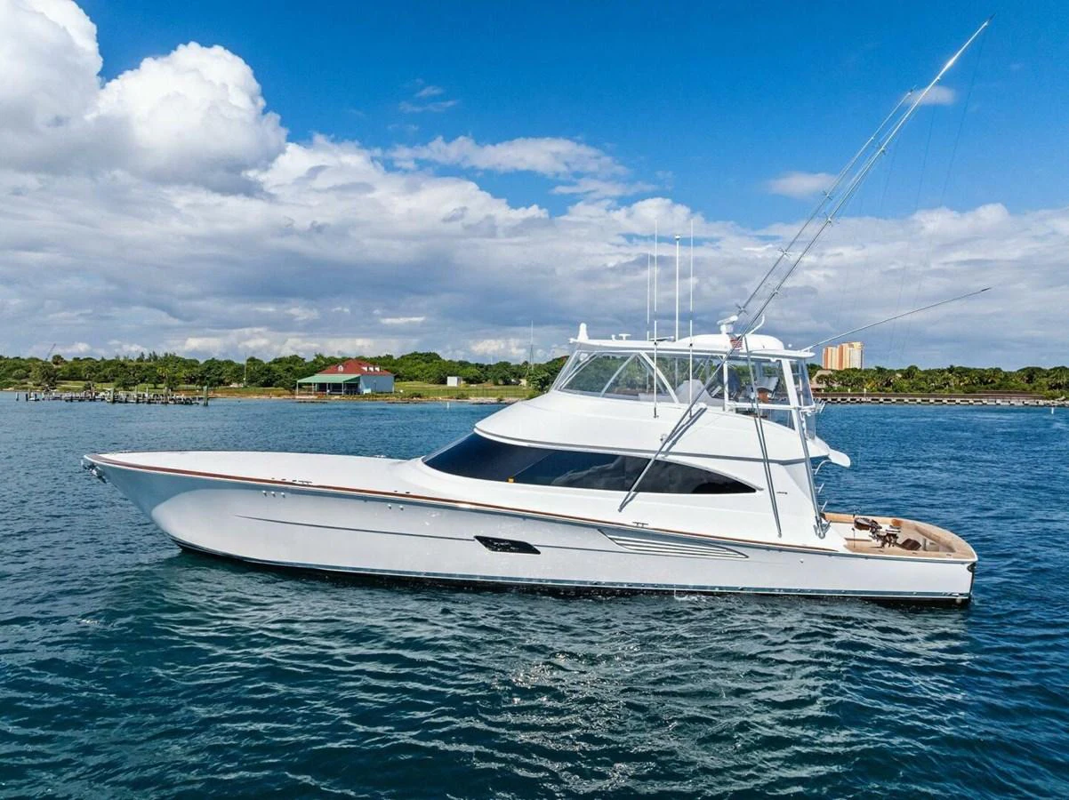A sleek yacht cruises on calm waters under a bright blue sky. aboard TEAM HARVEY I Yacht for Sale