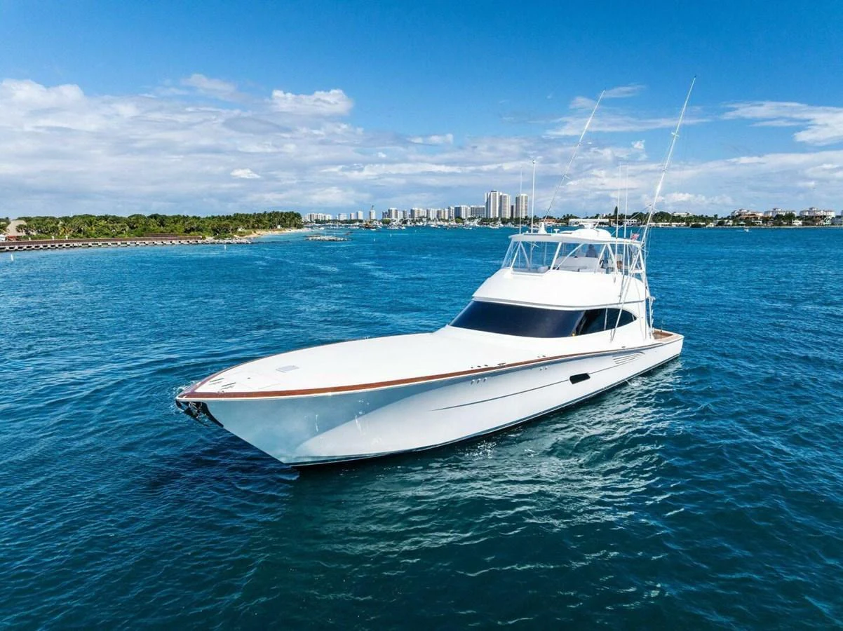 A sleek yacht glides through clear blue waters under a bright sky. aboard TEAM HARVEY I Yacht for Sale
