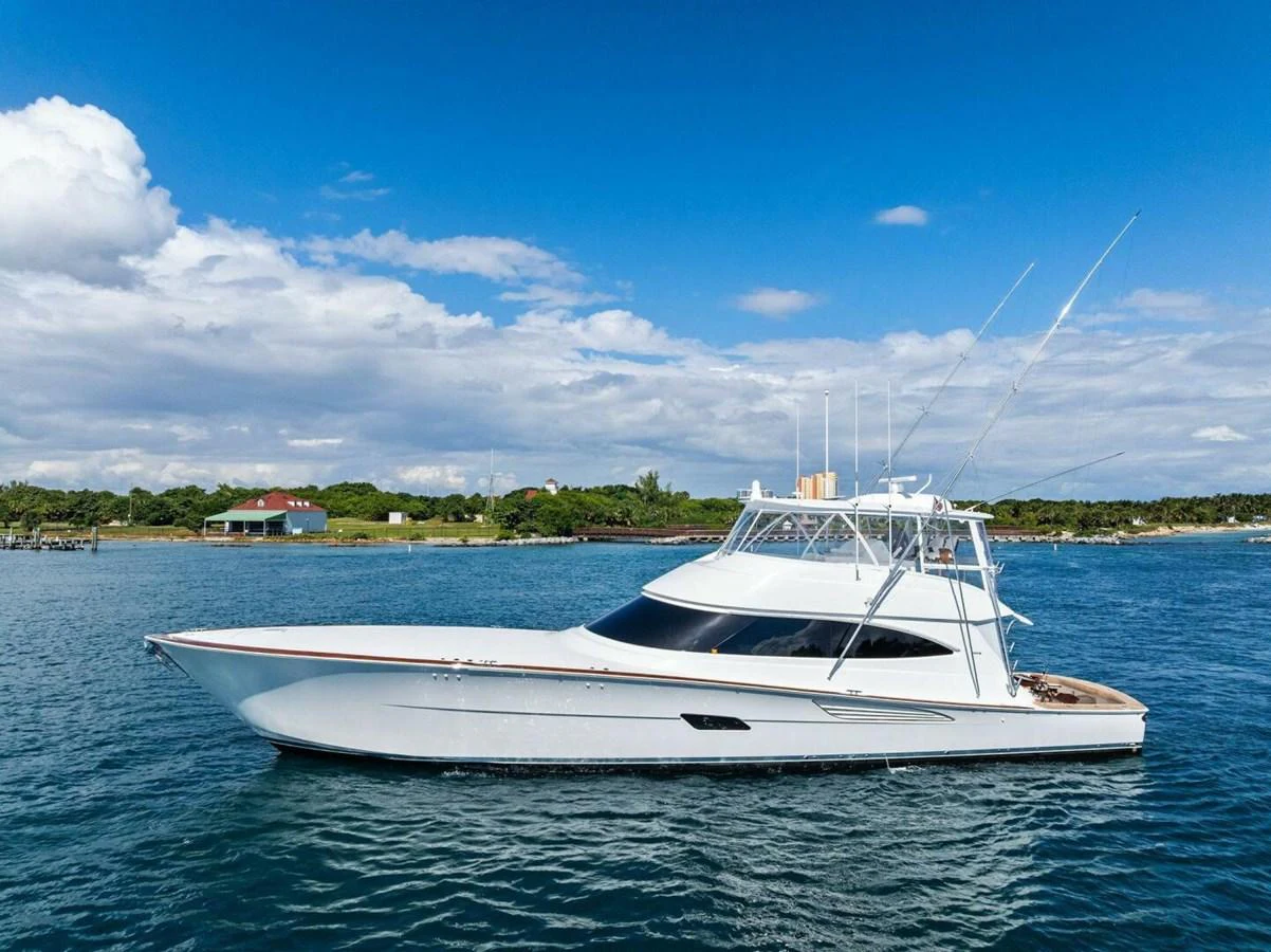 A sleek white yacht glides gracefully on calm waters under a clear blue sky. aboard TEAM HARVEY I Yacht for Sale