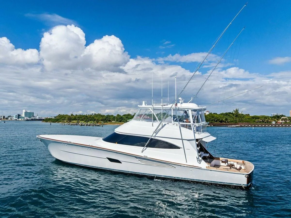 A sleek white yacht cruises gracefully on calm waters under a bright blue sky. aboard TEAM HARVEY I Yacht for Sale