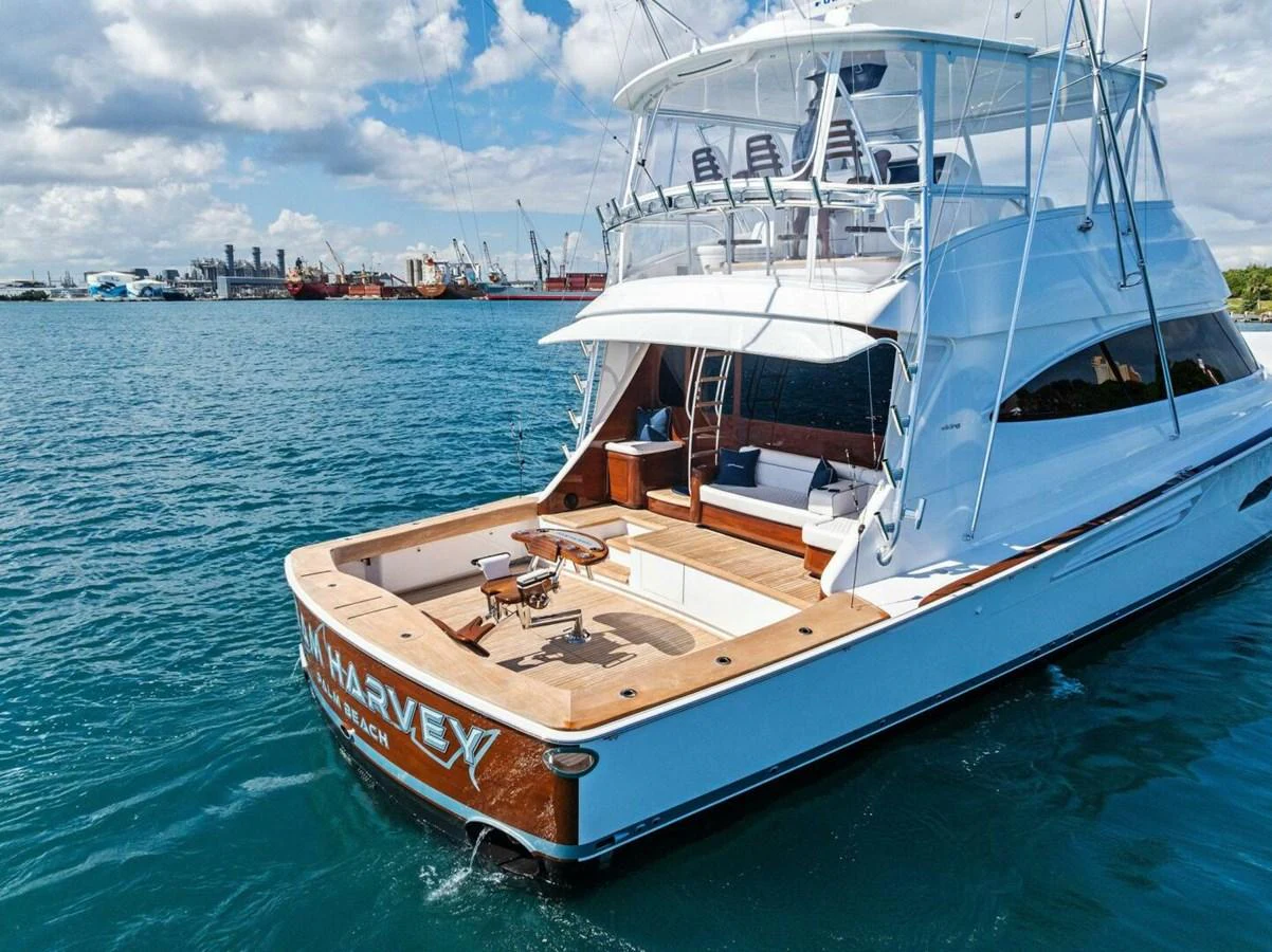 A luxurious yacht with a spacious aft deck is seen docked in a serene harbor. aboard TEAM HARVEY I Yacht for Sale