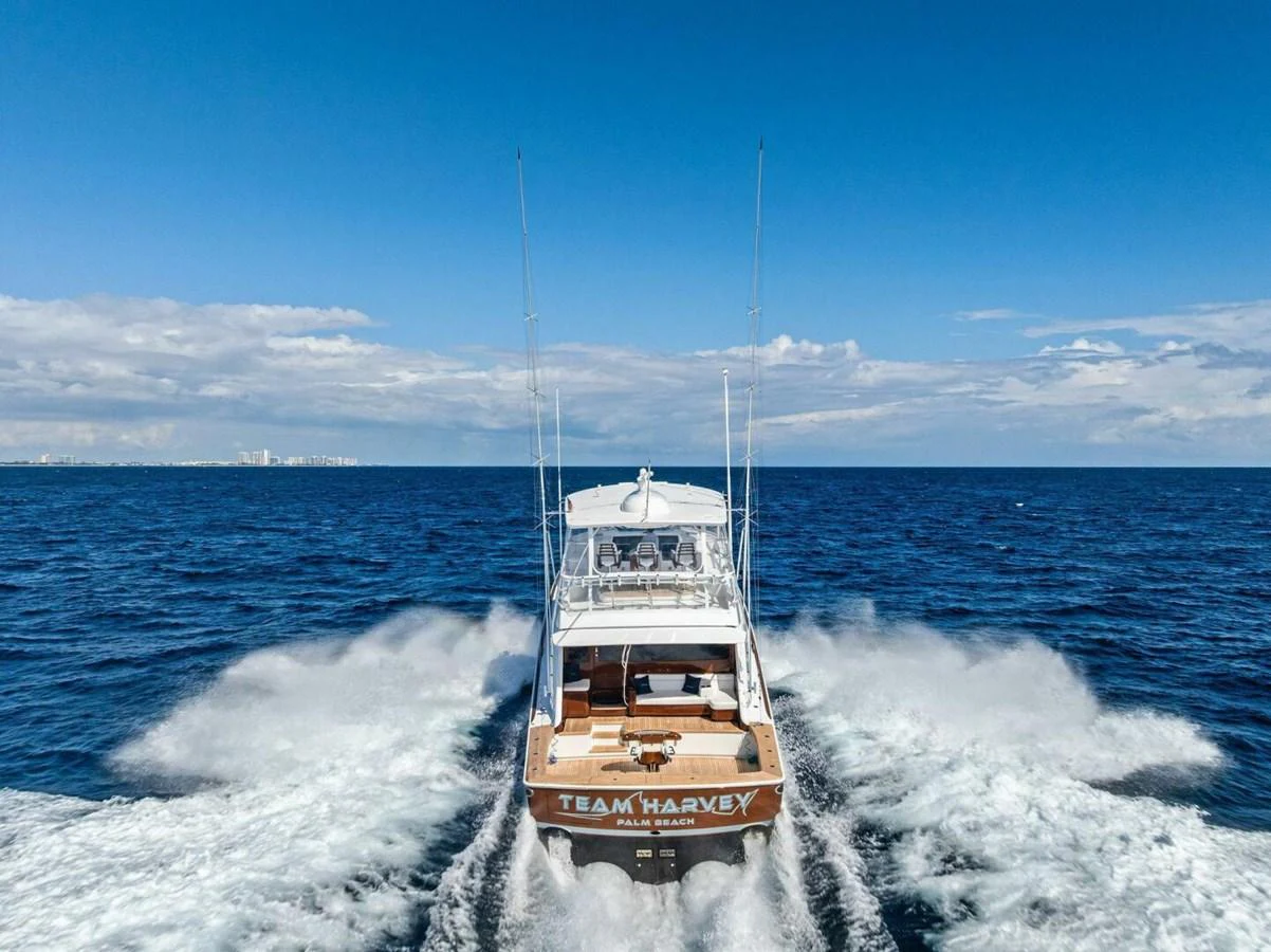 A yacht speeds across the open ocean, leaving a trail of white water behind. aboard TEAM HARVEY I Yacht for Sale