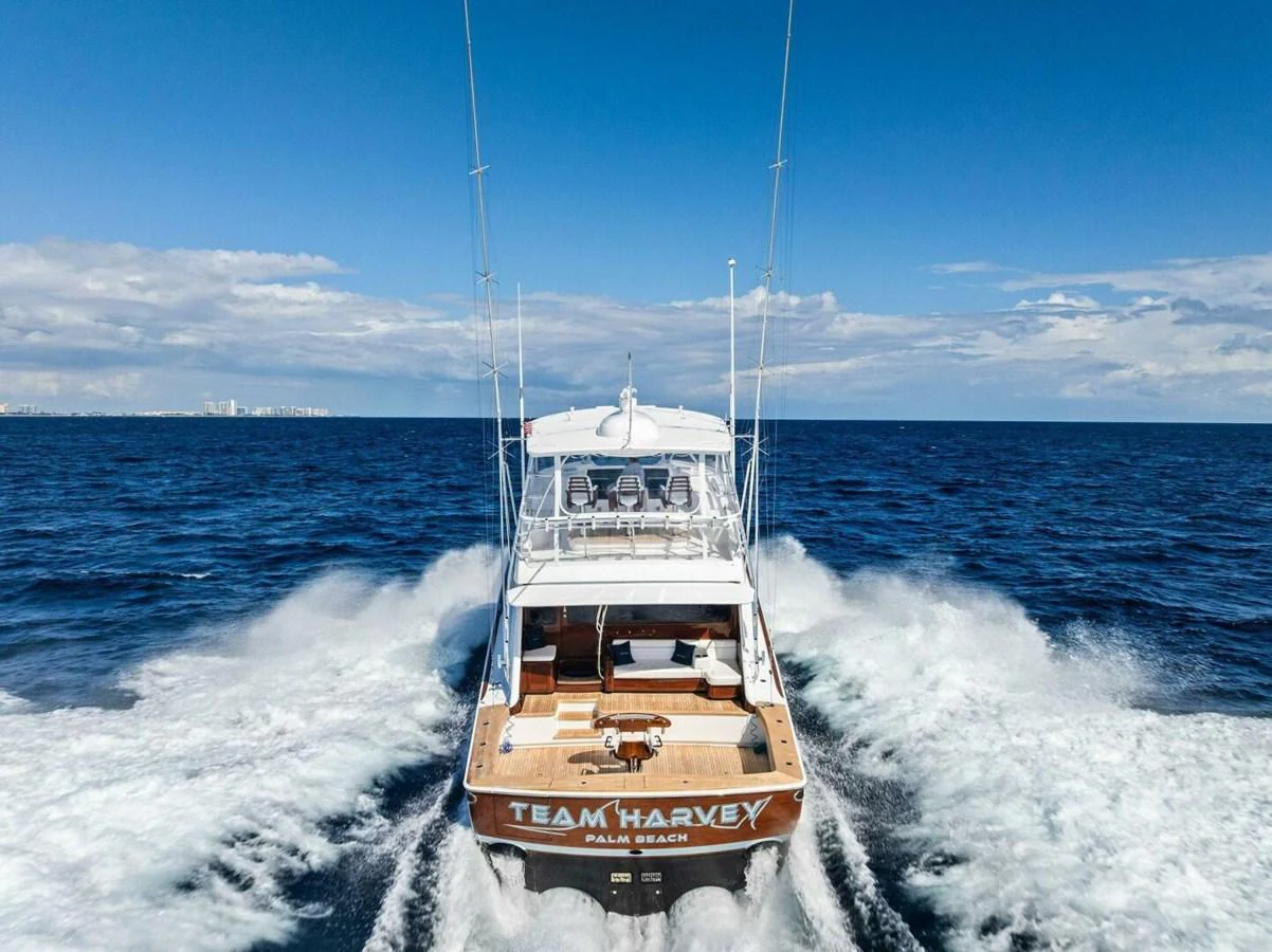 A sleek yacht cruises through the open sea, leaving a trail of white water behind. aboard TEAM HARVEY I Yacht for Sale