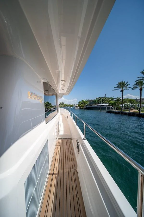 A sleek side deck of a yacht with a view of the water and palm trees in the background. aboard NEW BOAT Yacht for Sale