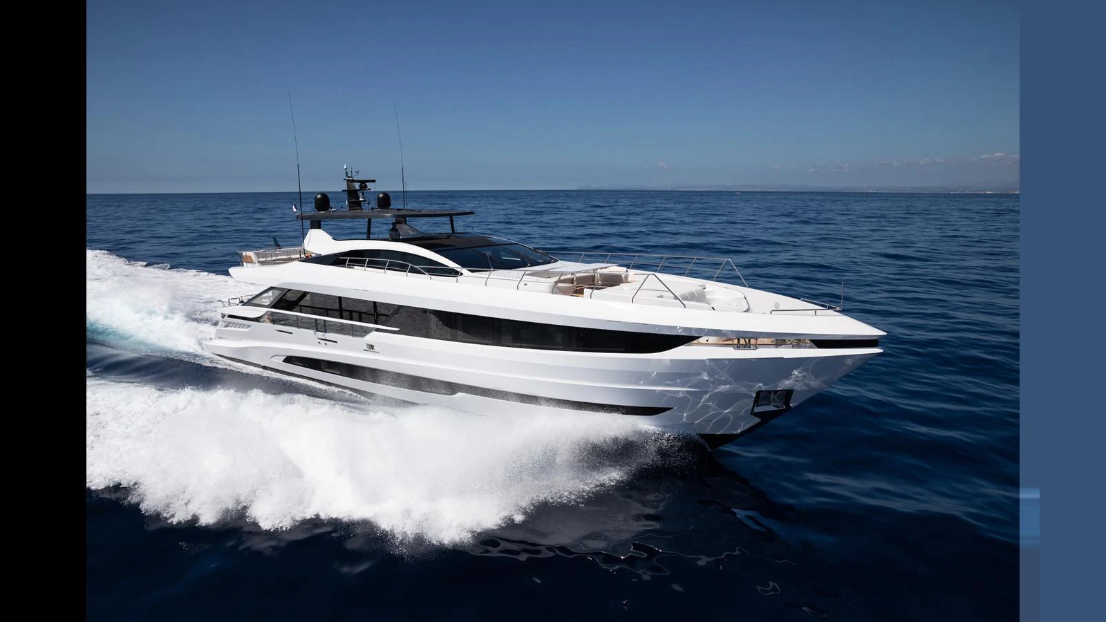 A sleek and modern yacht glides swiftly across the open sea under a clear blue sky. aboard ARTEMIS Yacht for Sale