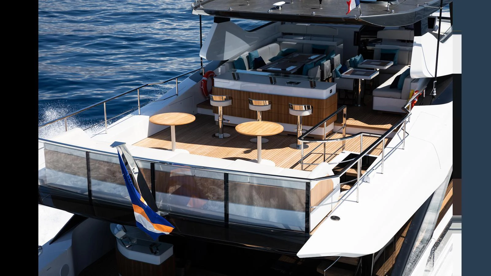 The yacht's aft deck features a spacious seating area with bar stools and tables, perfect for outdoor relaxation and dining. aboard ARTEMIS Yacht for Sale