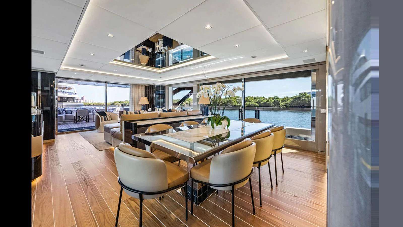 The yacht's dining area features elegant seating and expansive windows offering stunning water views. aboard ARTEMIS Yacht for Sale