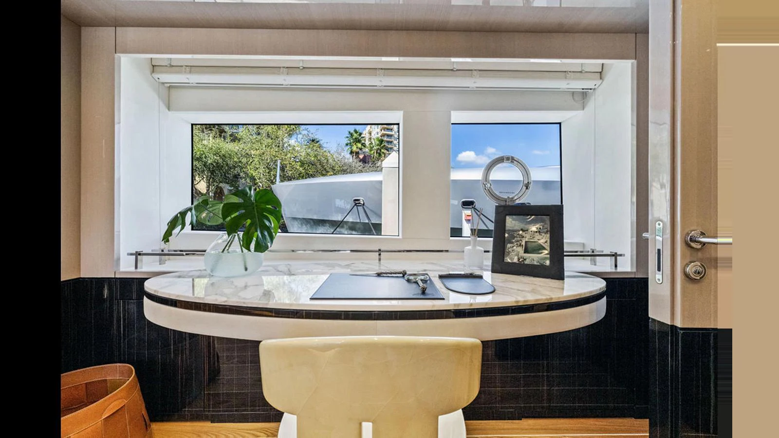 A stylish interior workspace with a view of the outside through large windows. aboard ARTEMIS Yacht for Sale