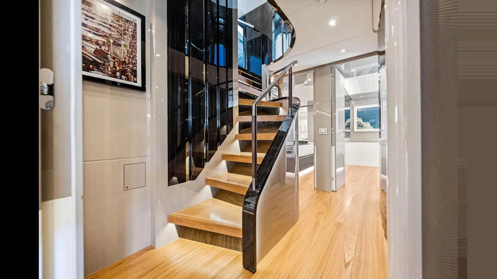 A luxurious interior featuring a modern staircase with sleek wooden steps and elegant railings. aboard ARTEMIS Yacht for Sale