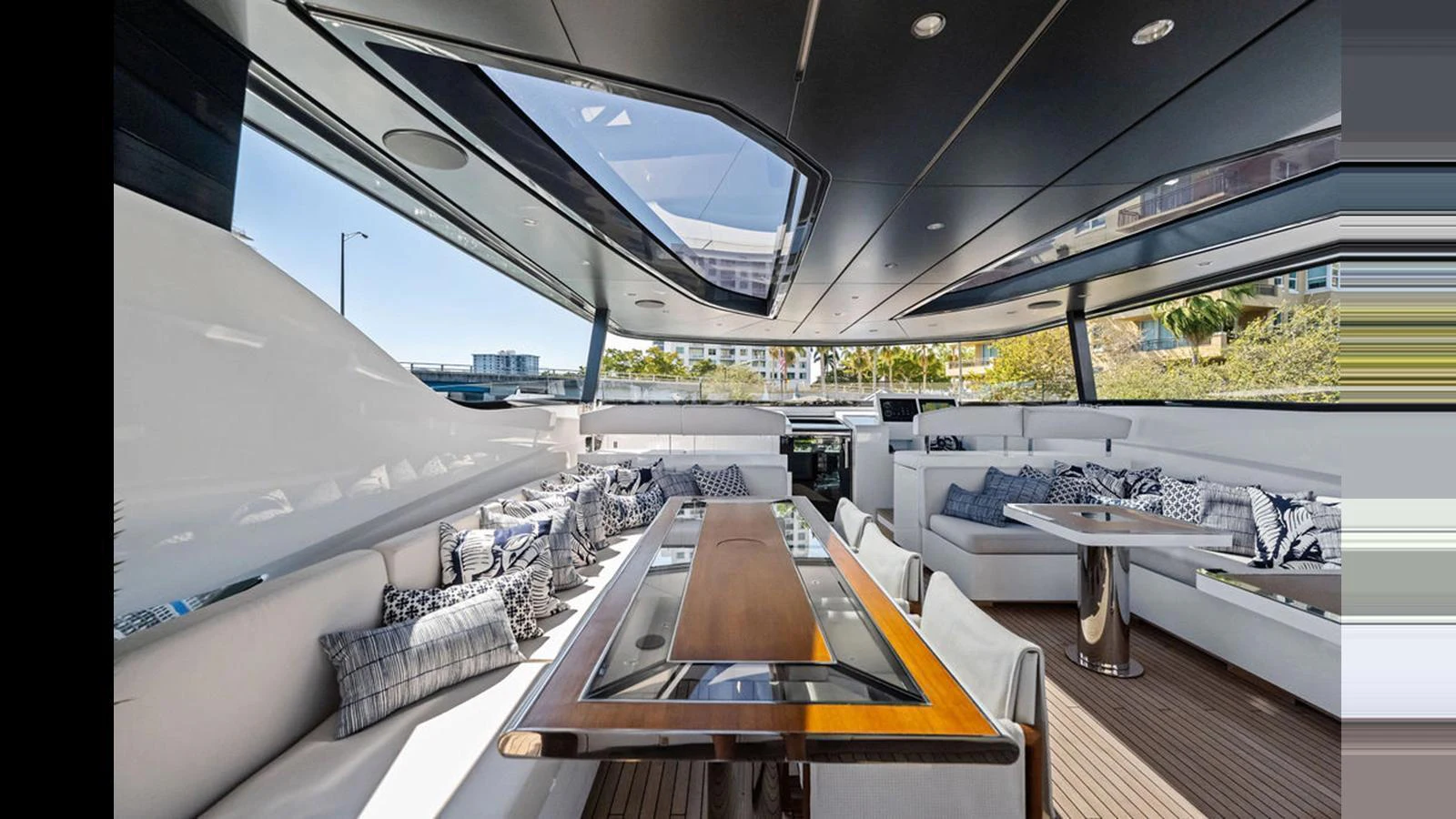 The spacious saloon features elegant seating and a large dining table under a sleek, modern roof with skylights. aboard ARTEMIS Yacht for Sale
