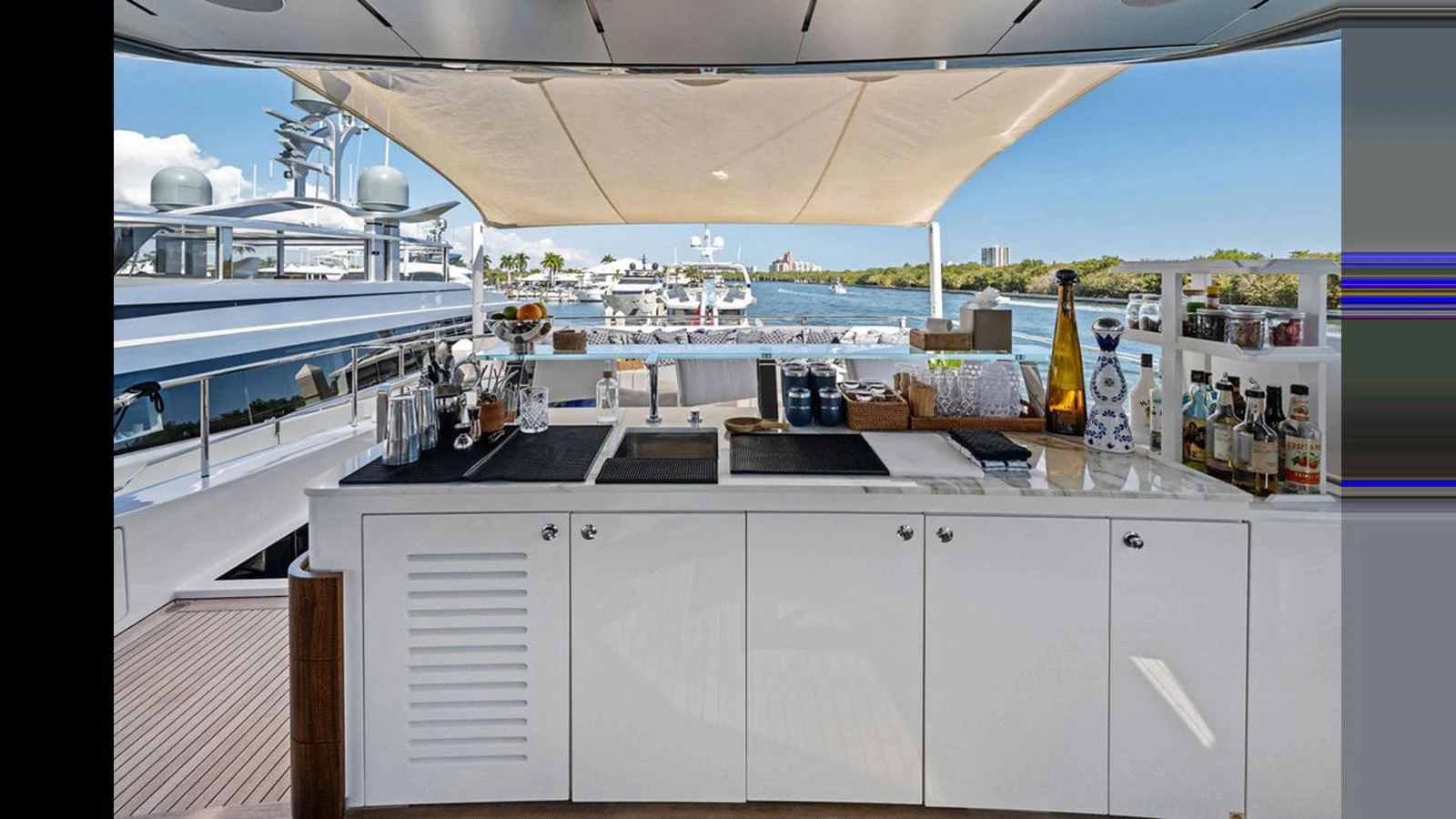 This yacht features a well-equipped outdoor bar with a scenic view of the marina. aboard ARTEMIS Yacht for Sale