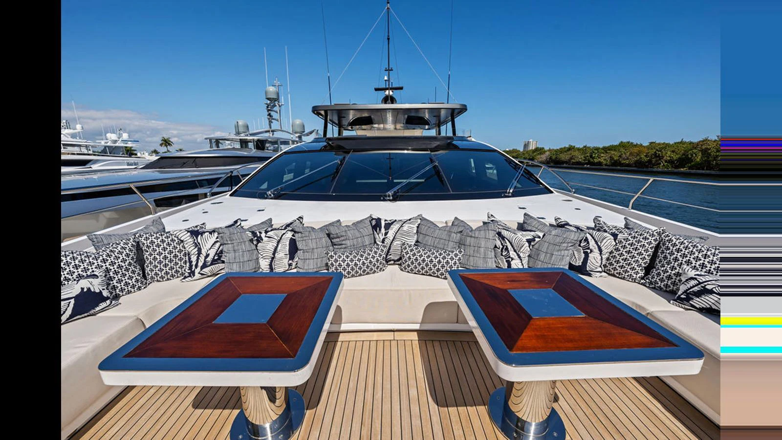 The yacht's foredeck features a stylish seating area with two elegant tables and plush cushions, perfect for relaxation. aboard ARTEMIS Yacht for Sale