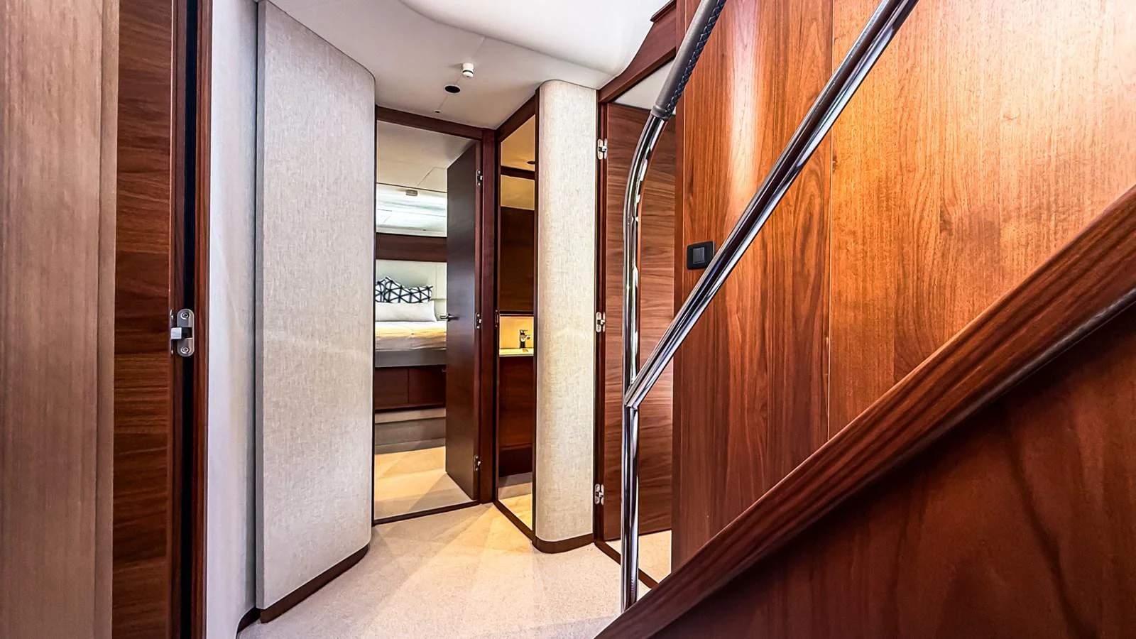 The yacht's interior features a polished wooden staircase and hallway leading to various rooms. aboard NAUTILUS Yacht for Sale