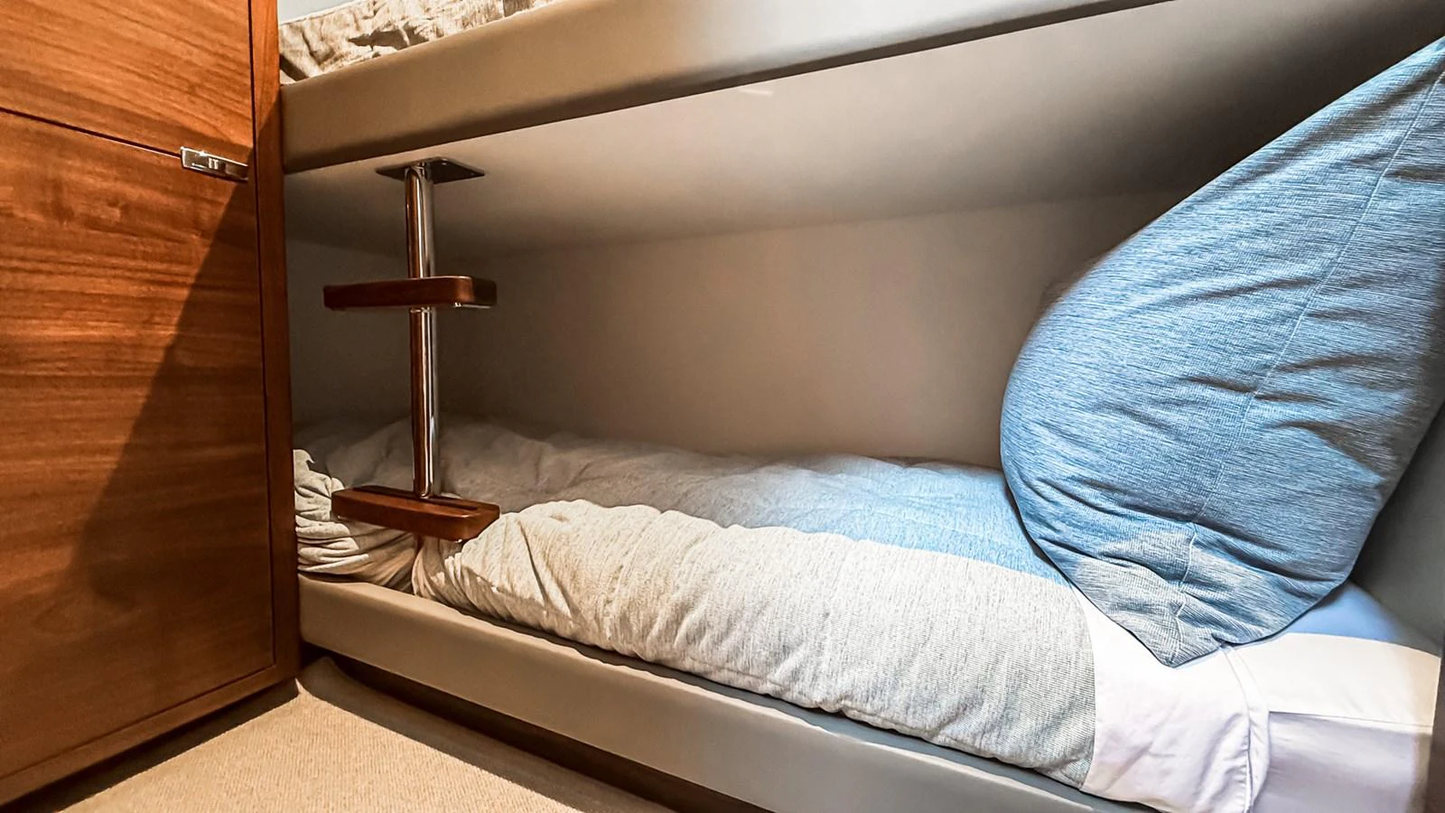 The image shows a cozy bunk cabin with neatly arranged bedding and wooden accents. aboard NAUTILUS Yacht for Sale