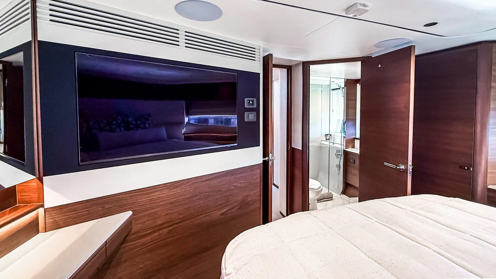 The stateroom features a comfortable bed, modern wood finishes, and an en-suite bathroom. aboard NAUTILUS Yacht for Sale