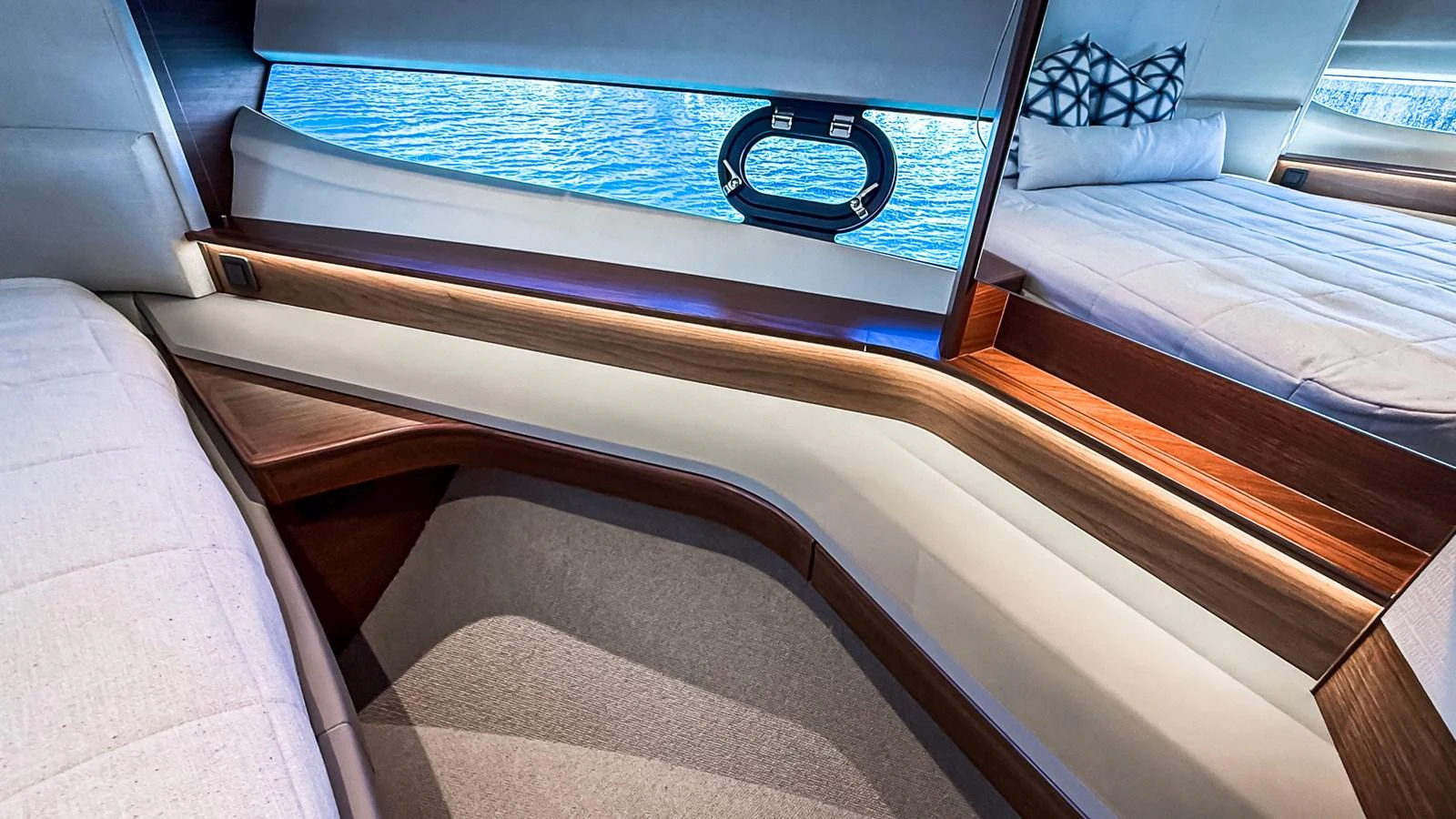 The stateroom features modern design elements with luxurious bedding and a view of the water through a porthole. aboard NAUTILUS Yacht for Sale