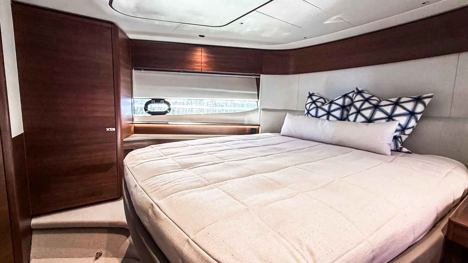 A cozy and well-appointed stateroom featuring a large bed and modern wood finishes. aboard NAUTILUS Yacht for Sale