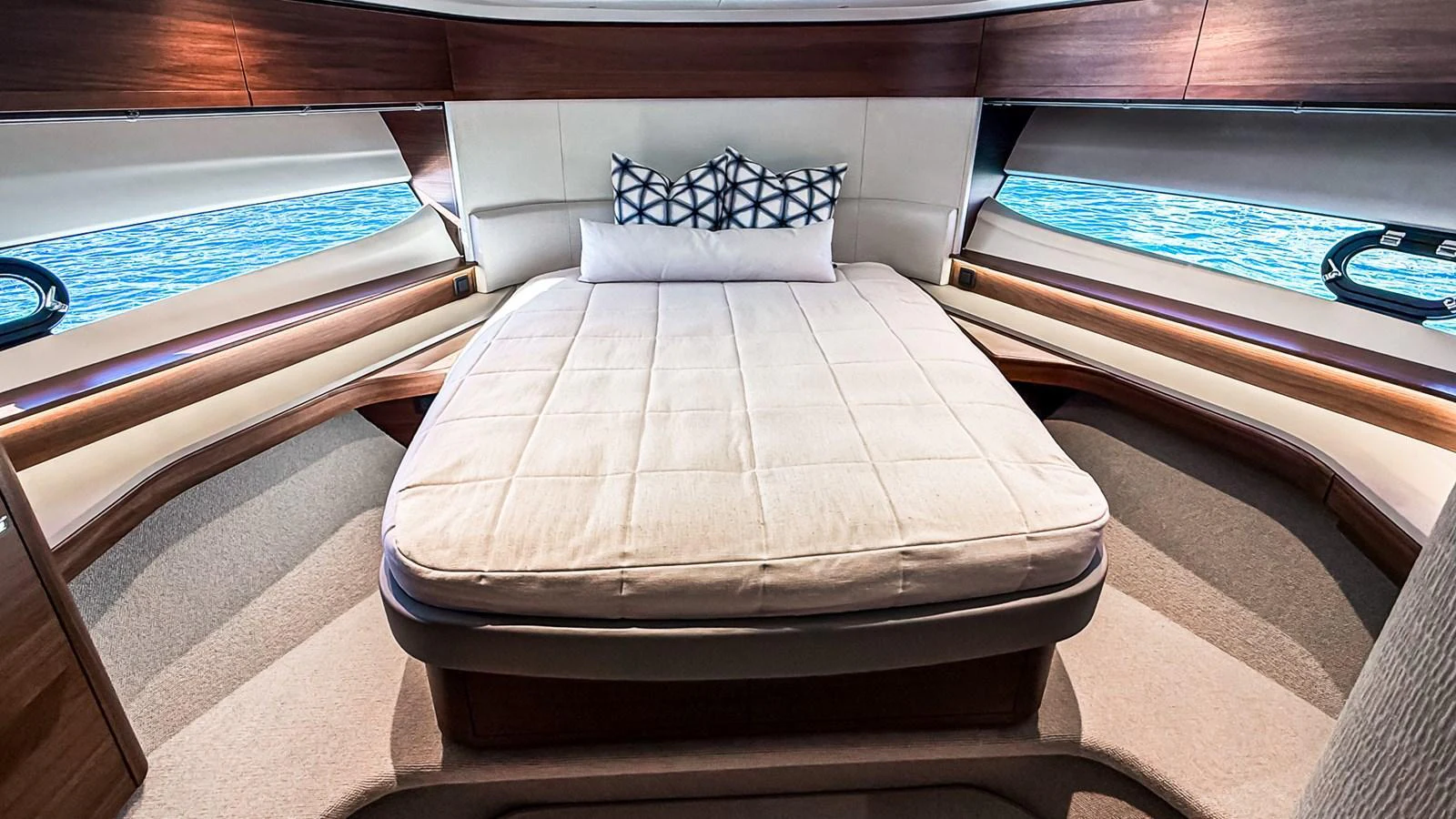 The stateroom features a plush bed with elegant wood finishes and panoramic windows offering serene water views. aboard NAUTILUS Yacht for Sale