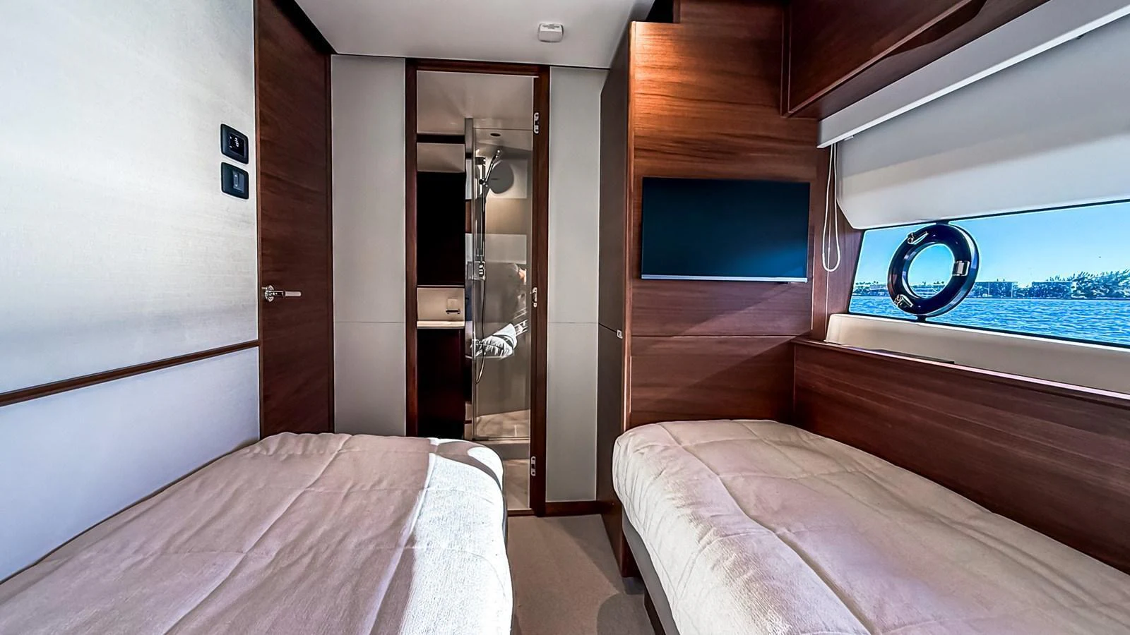The guest stateroom features twin beds, a large window with a view, and a modern ensuite bathroom. aboard NAUTILUS Yacht for Sale