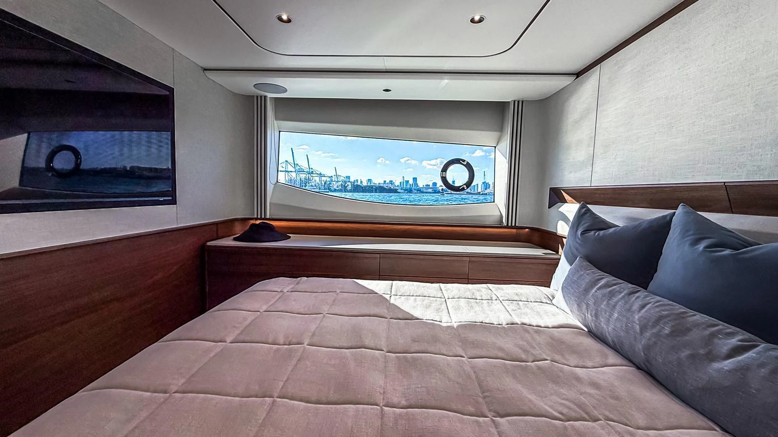 A luxurious stateroom with a large window offering a stunning view of the city skyline. aboard NAUTILUS Yacht for Sale
