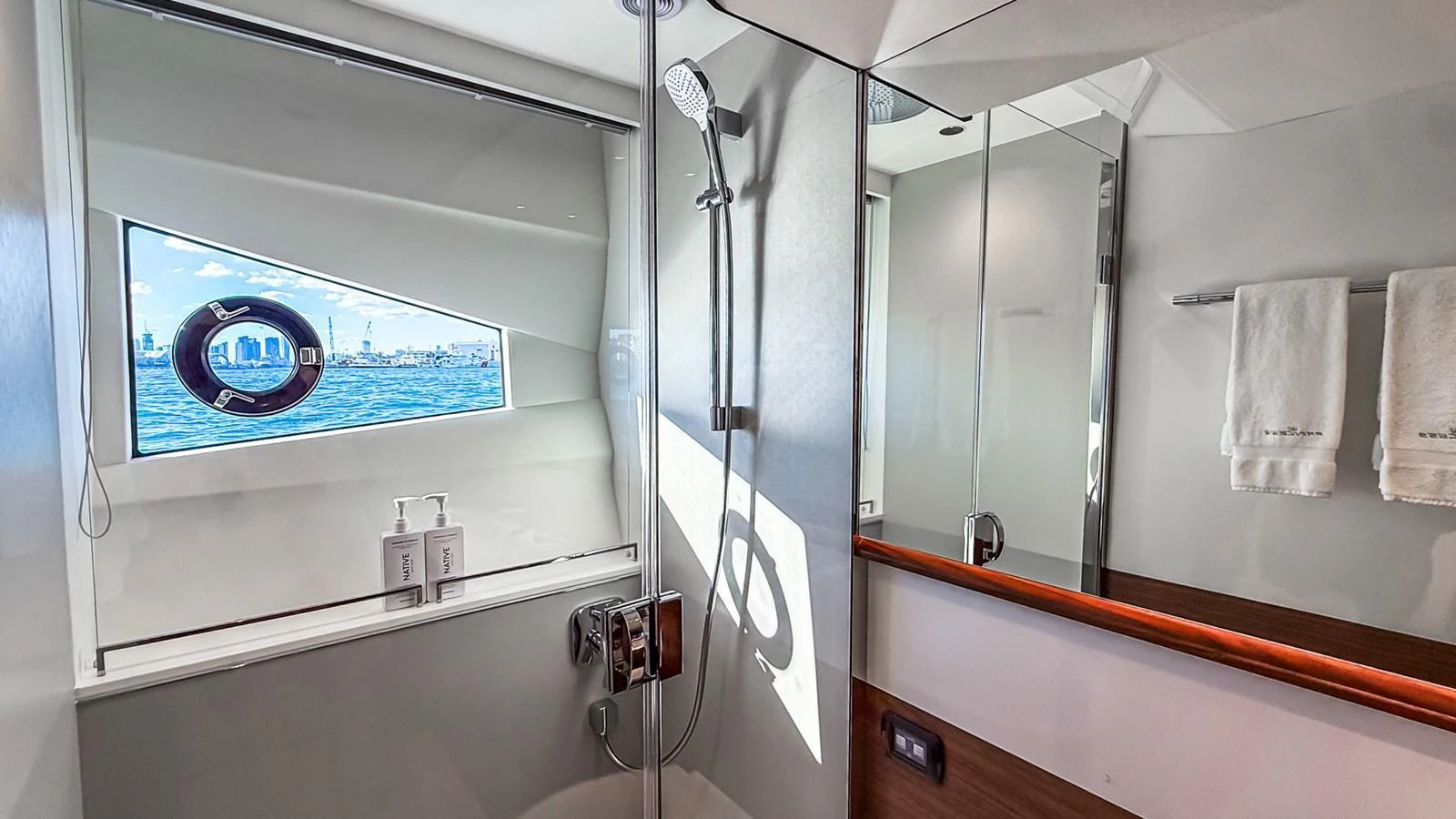 A modern yacht bathroom with a sleek shower area and a window offering a view of the sea. aboard NAUTILUS Yacht for Sale