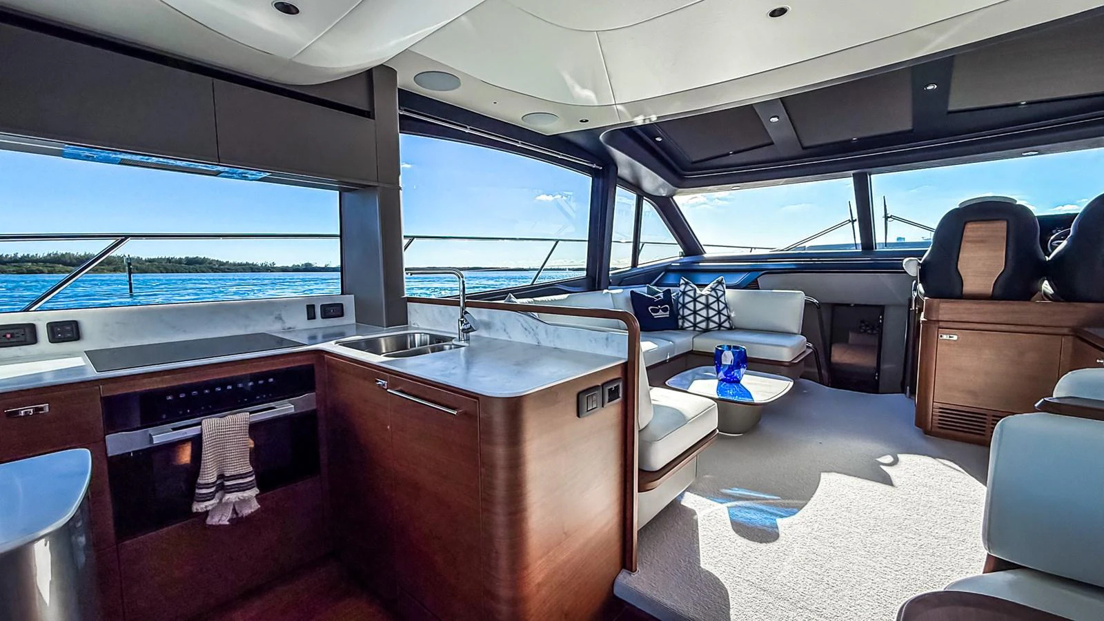 The salon features a modern design with a well-equipped galley and comfortable seating area, offering panoramic views through large windows. aboard NAUTILUS Yacht for Sale