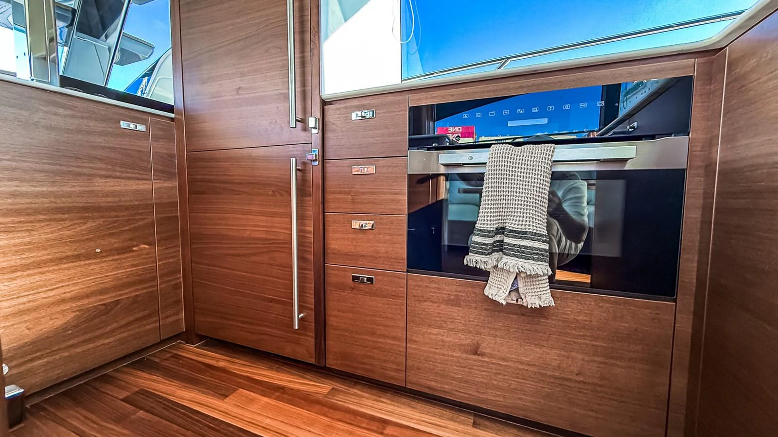 The yacht's galley features sleek wooden cabinetry and modern appliances, creating a warm and functional space. aboard NAUTILUS Yacht for Sale