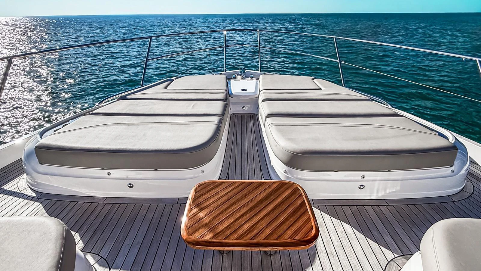 The foredeck features spacious sun pads and a sleek wooden table, perfect for relaxation and enjoying the ocean view. aboard NAUTILUS Yacht for Sale