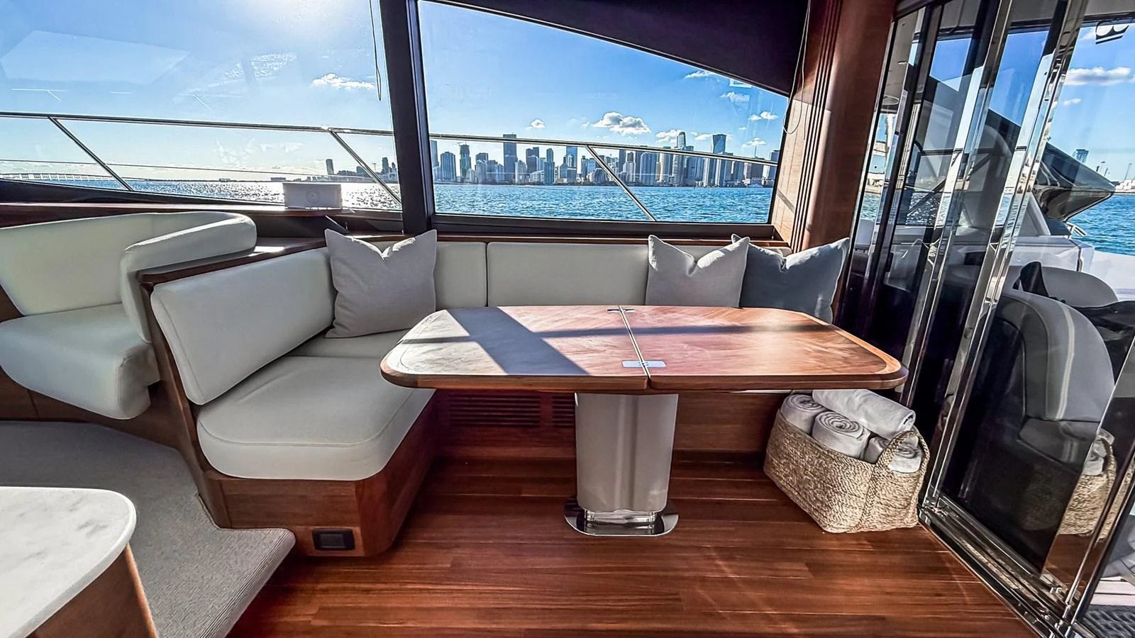 The salon features a comfortable seating area with a wooden table and panoramic windows offering stunning city views. aboard NAUTILUS Yacht for Sale