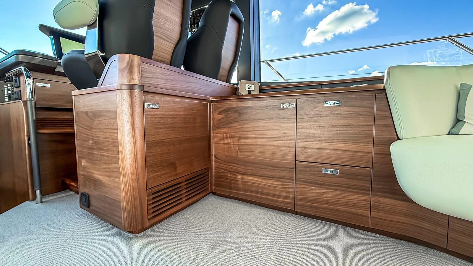 The helm area features luxurious wood cabinetry and comfortable seating with a view of the clear blue sky. aboard NAUTILUS Yacht for Sale