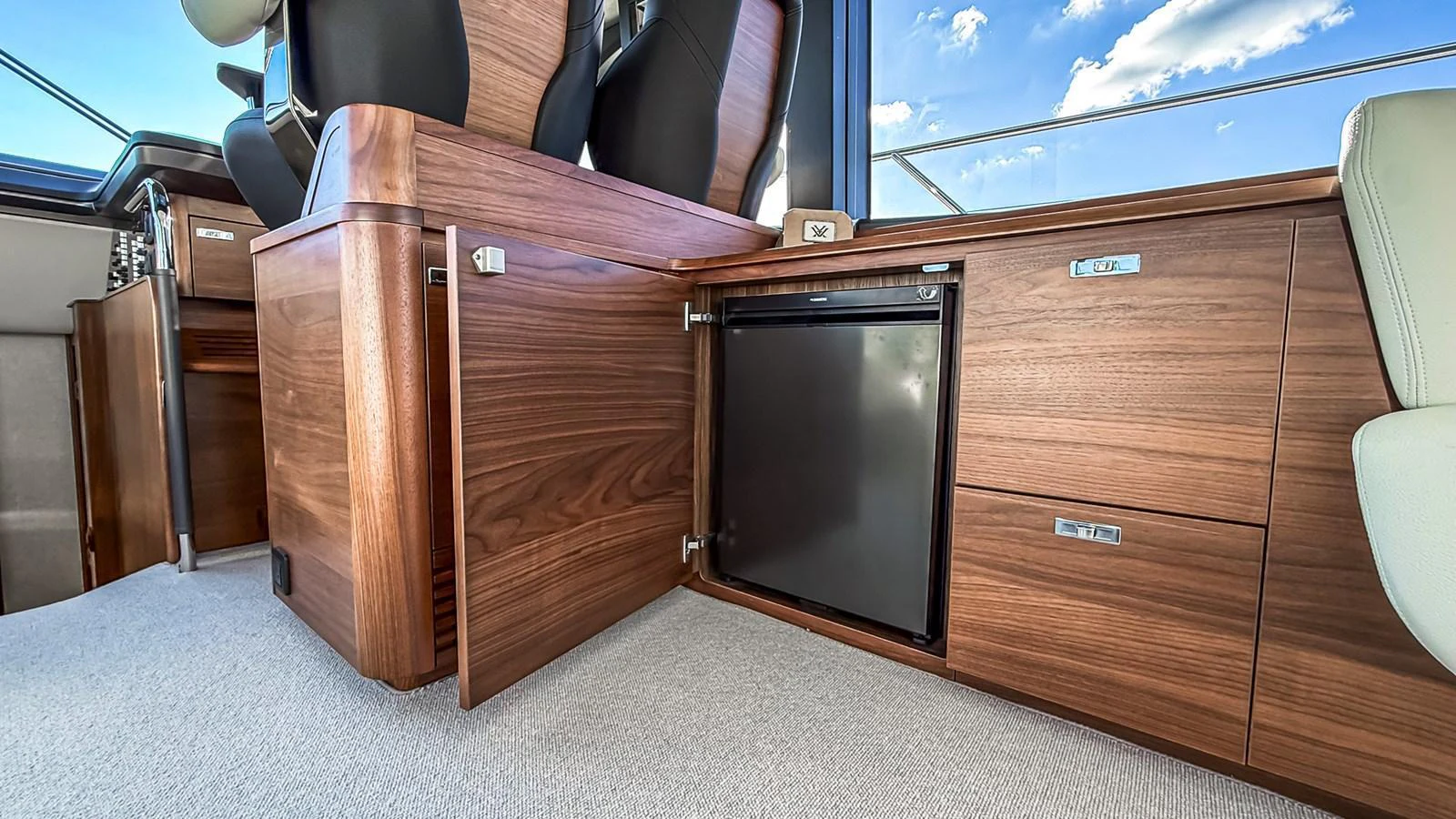The yacht's interior features elegant wooden cabinetry and a built-in refrigerator, offering both style and functionality. aboard NAUTILUS Yacht for Sale