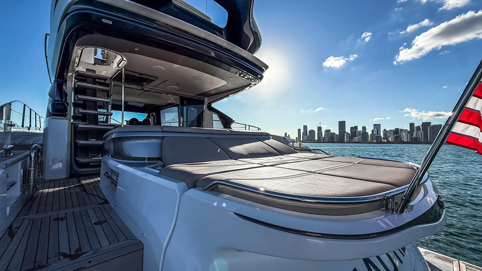 The yacht's aft deck offers a spacious lounging area with a stunning city skyline in the background. aboard NAUTILUS Yacht for Sale