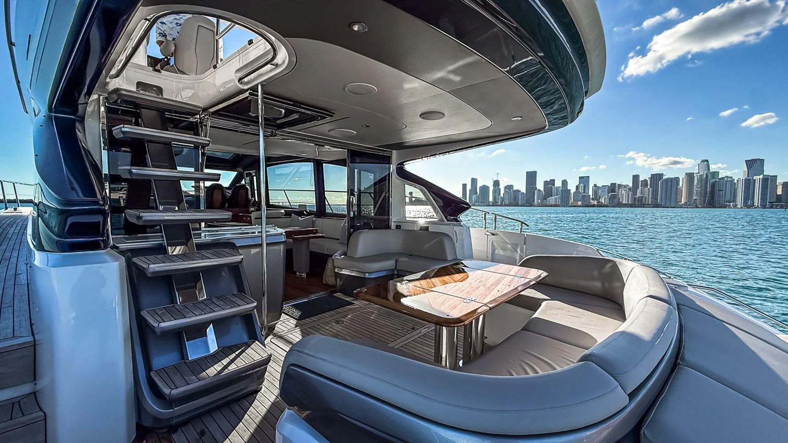 The yacht's aft deck features a luxurious seating area with a stunning city skyline in the background. aboard NAUTILUS Yacht for Sale