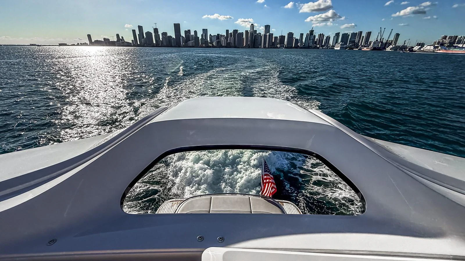 A stunning view from the aft deck of a yacht, cruising towards a city skyline. aboard NAUTILUS Yacht for Sale