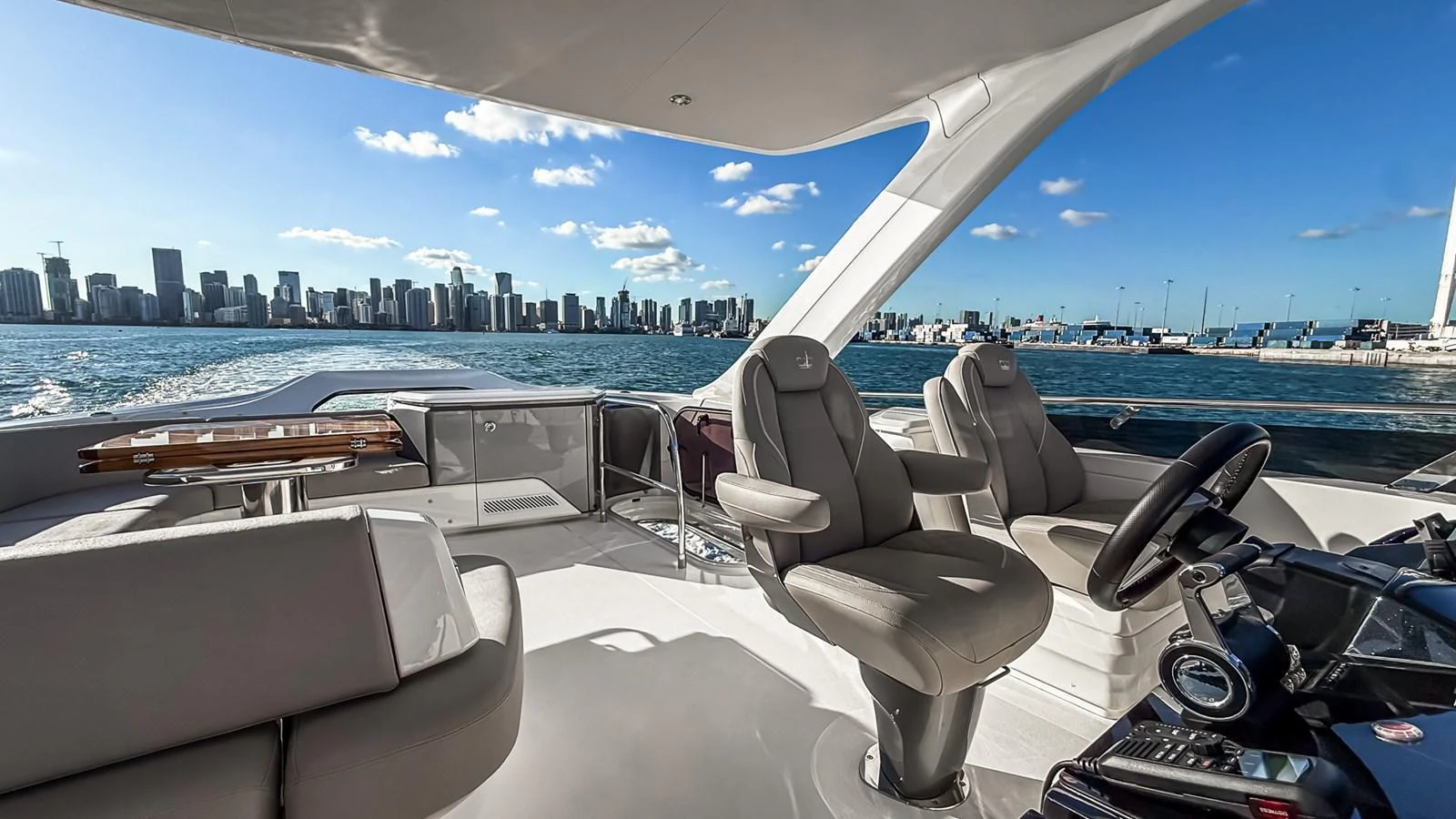 The yacht's helm offers a luxurious and comfortable seating area with a stunning city skyline in the background. aboard NAUTILUS Yacht for Sale