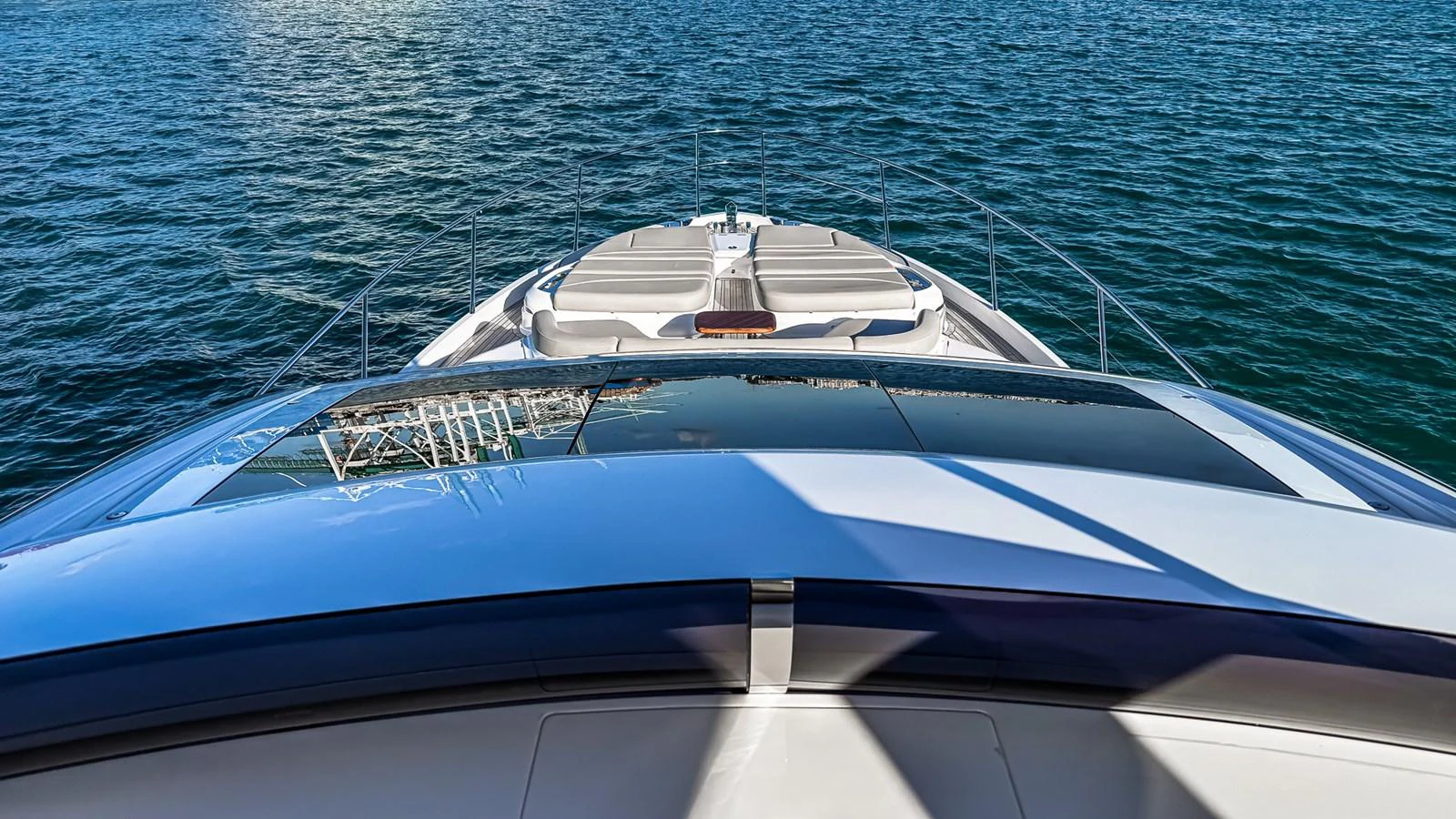 The yacht's sleek bow is seen cutting through calm waters, showcasing its modern design and luxurious sunpads. aboard NAUTILUS Yacht for Sale