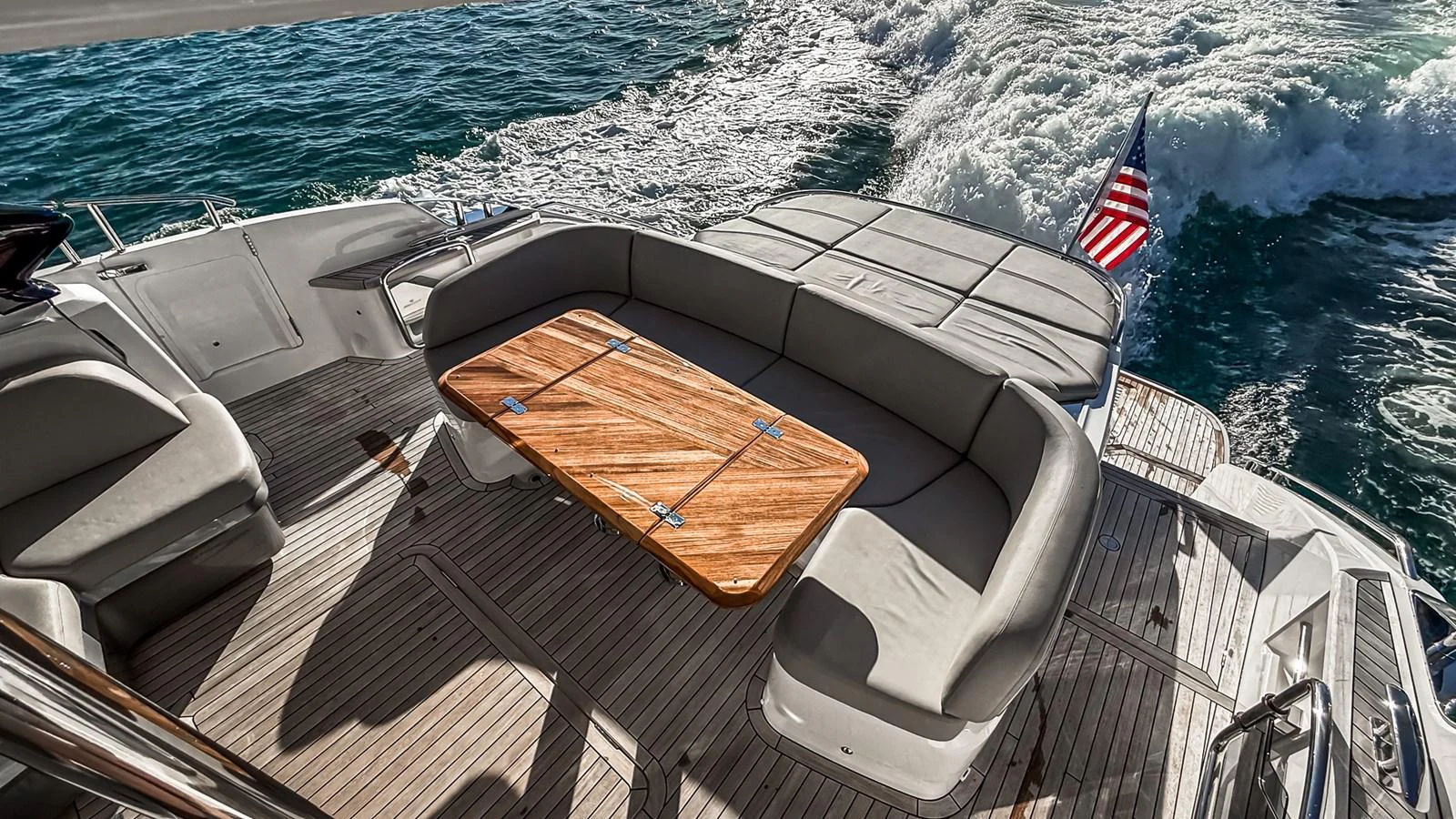 The aft deck features a comfortable seating area with a wooden table, perfect for enjoying the ocean views. aboard NAUTILUS Yacht for Sale