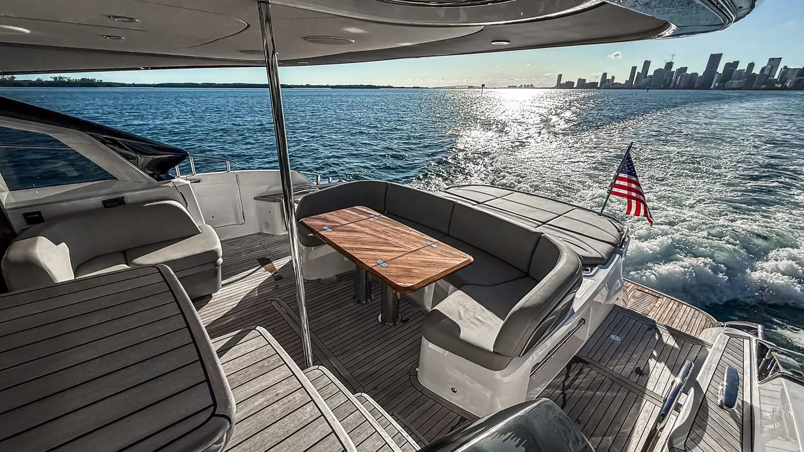 The aft deck offers a spacious seating area with a wooden table, perfect for enjoying the ocean views. aboard NAUTILUS Yacht for Sale