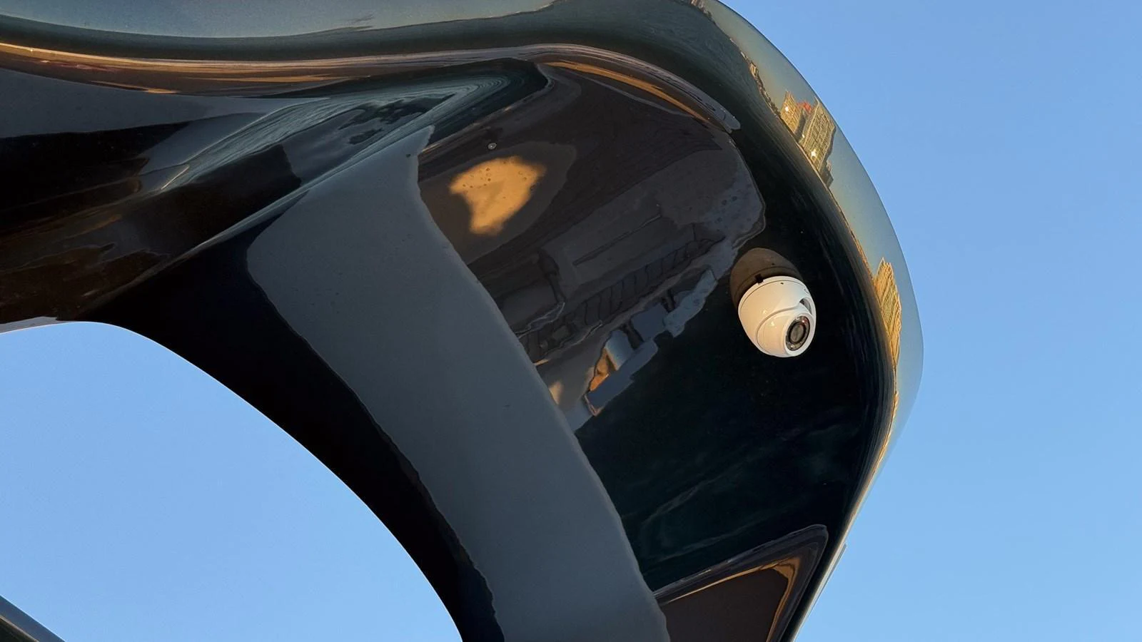 A close-up view of the yacht's sleek, black exterior with a security camera installed. aboard NAUTILUS Yacht for Sale