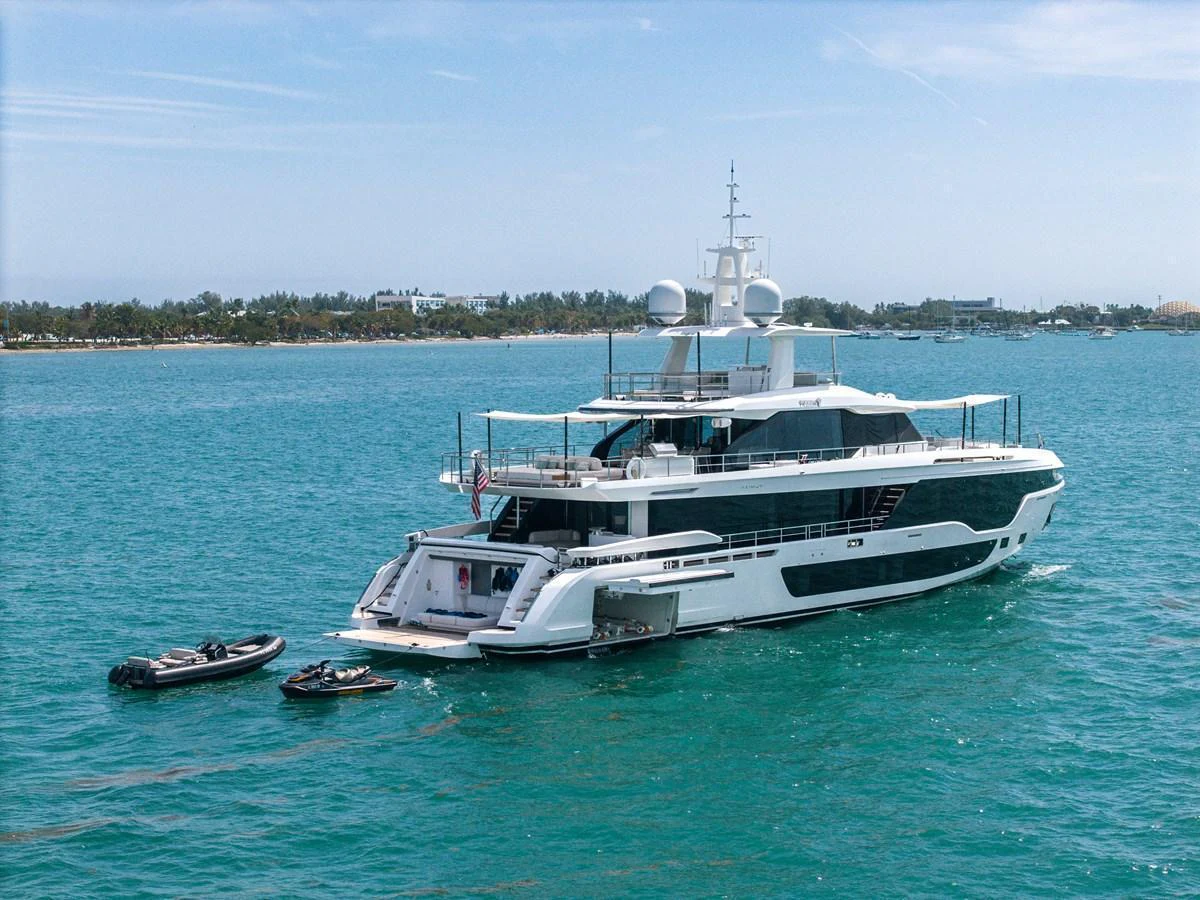 A luxurious yacht is anchored in clear blue waters, showcasing its sleek design and spacious decks. aboard TYCOON Yacht for Sale