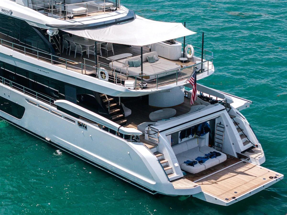 The yacht's aft deck features multiple lounging areas and direct access to the water. aboard TYCOON Yacht for Sale