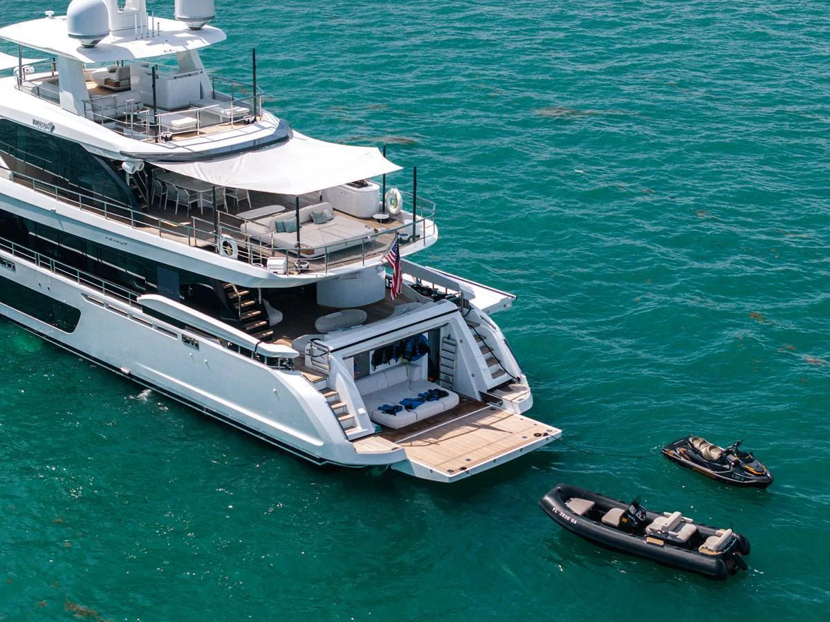 The yacht's aft deck features a spacious lounging area with easy access to the water and accompanying tenders. aboard TYCOON Yacht for Sale